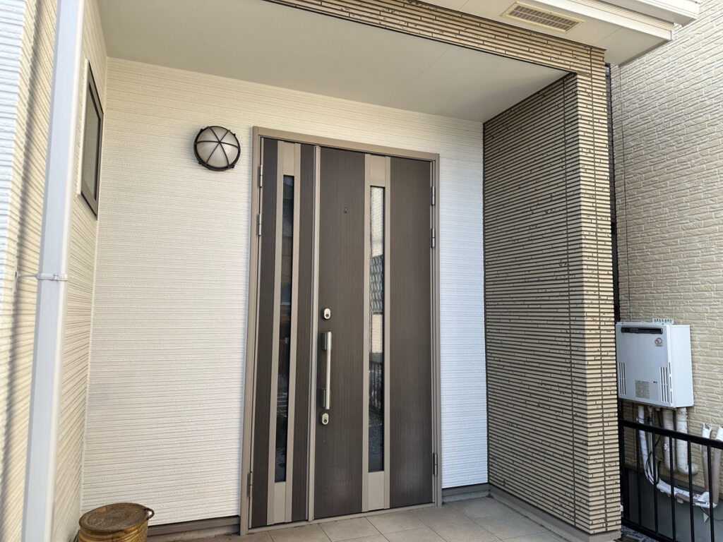ホワイトとブラウン系の外壁を組み合わせた戸建て住宅の玄関まわり